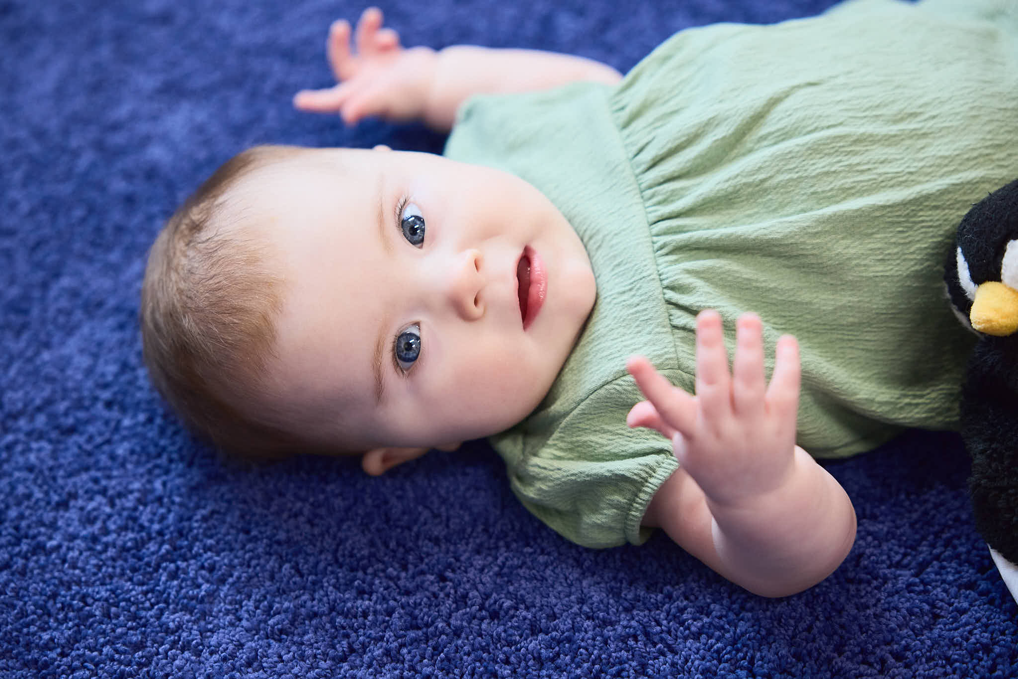 Infant laying on the ground looking at the camera