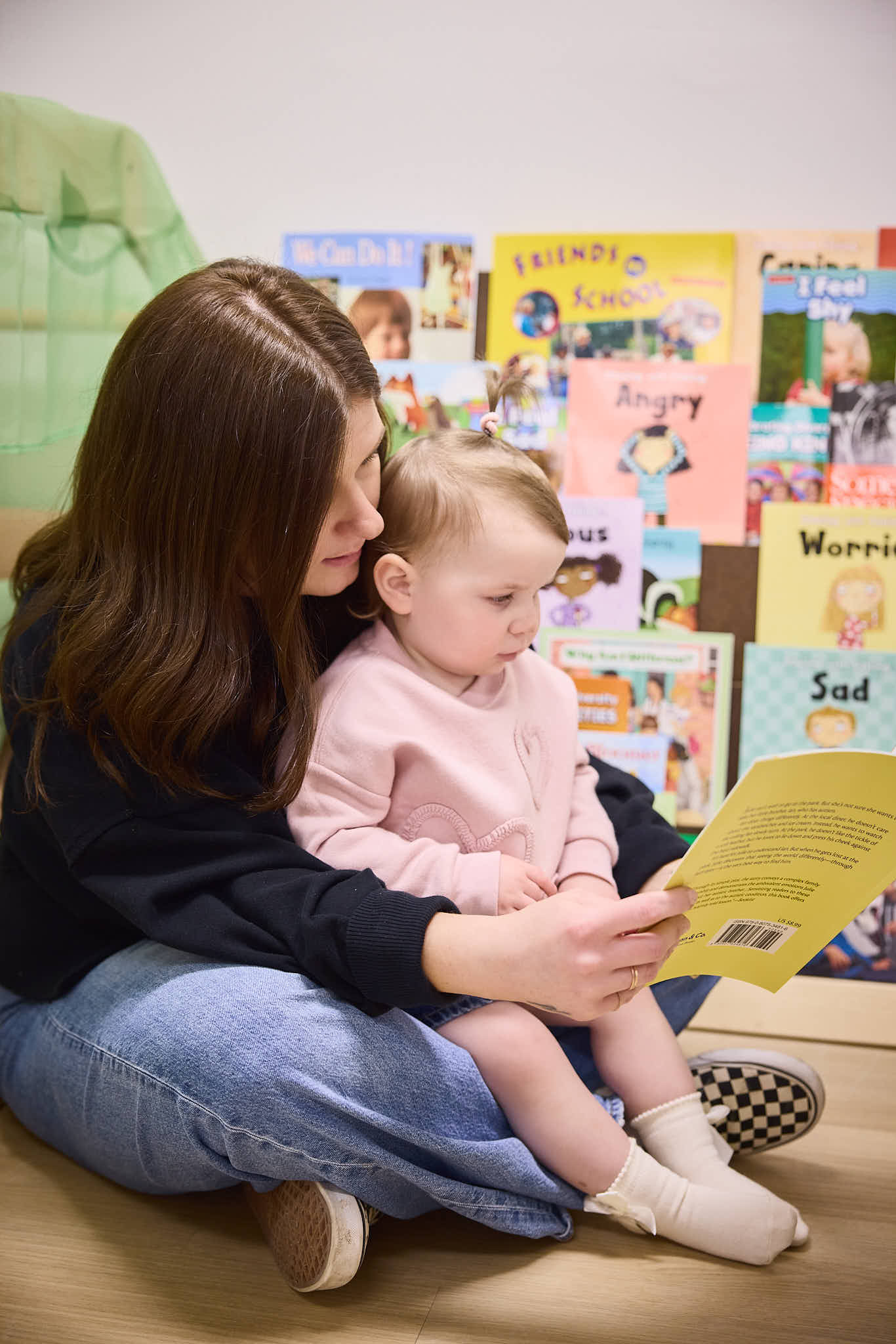Educator and Toddler reading a book together
