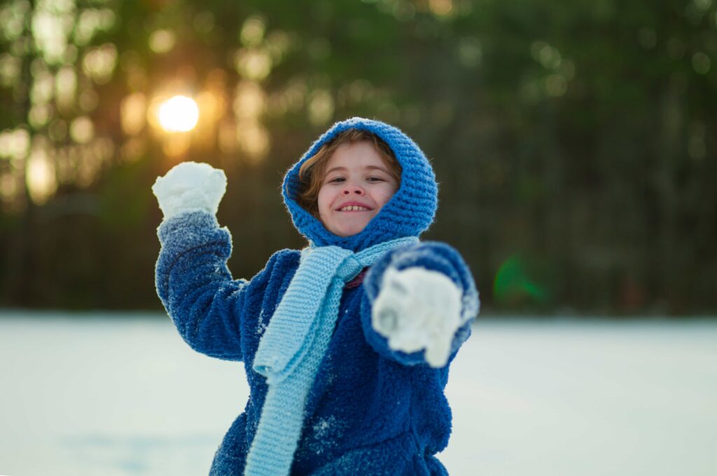 Little boy throwing snow